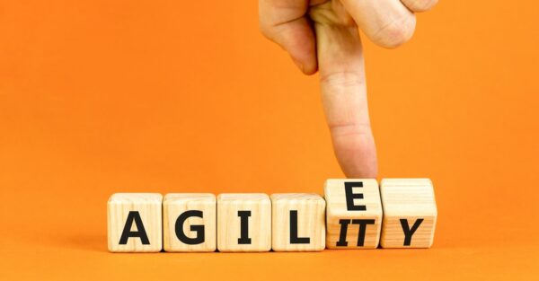 Finger moving letter blocks from spelling agile to agility